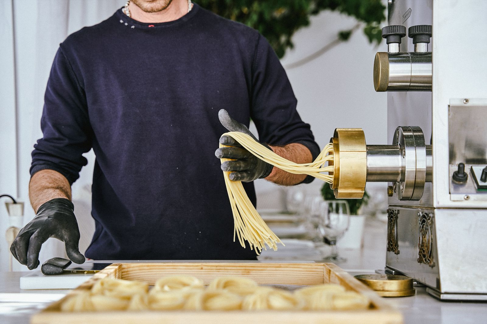 Chef extruding fresh spaghetti